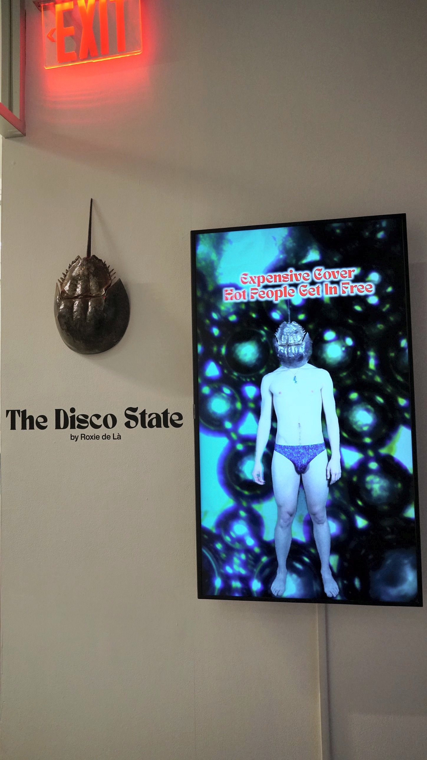The Bouncer under the exit sign, full-length figure on screen