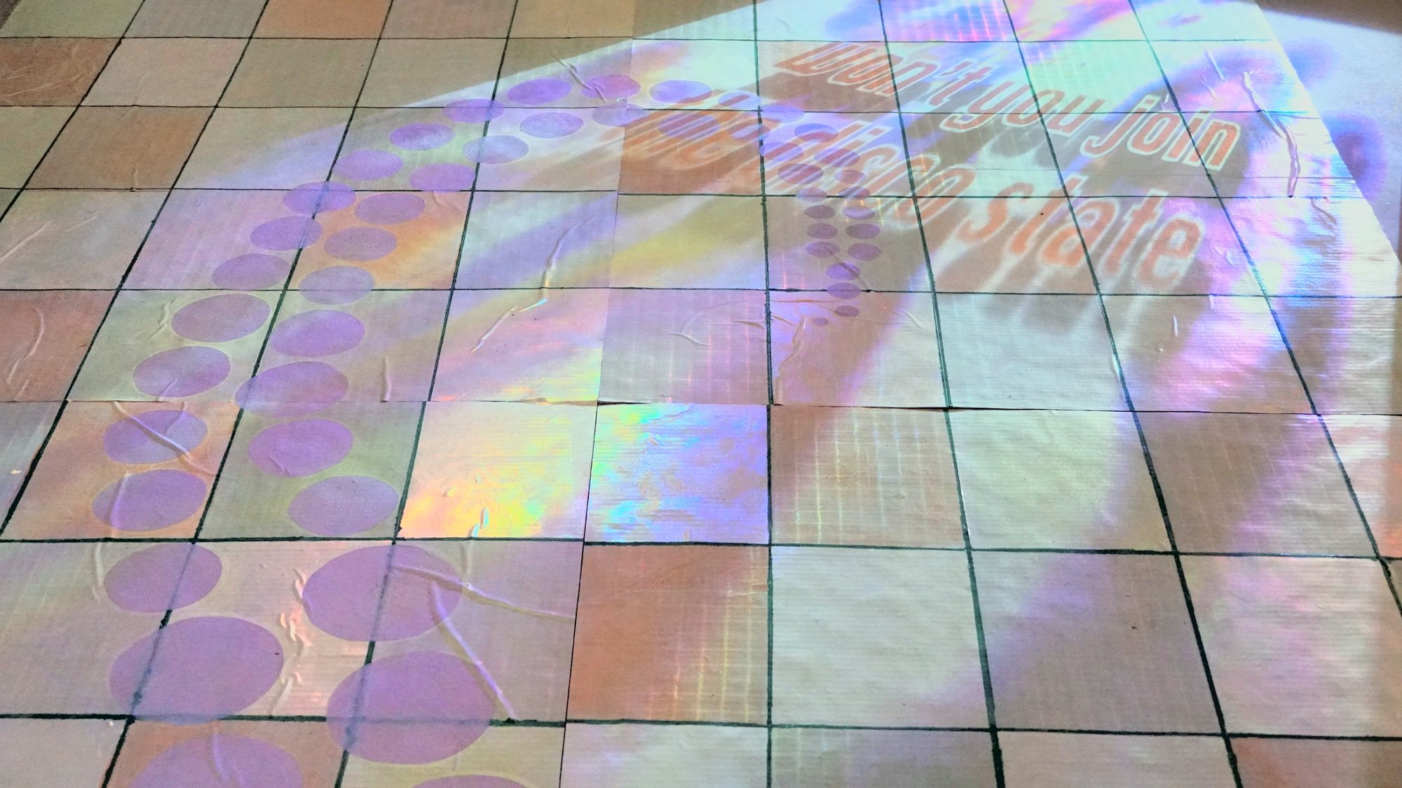 Close-up of the holographic tiles, purple circle path and projected text