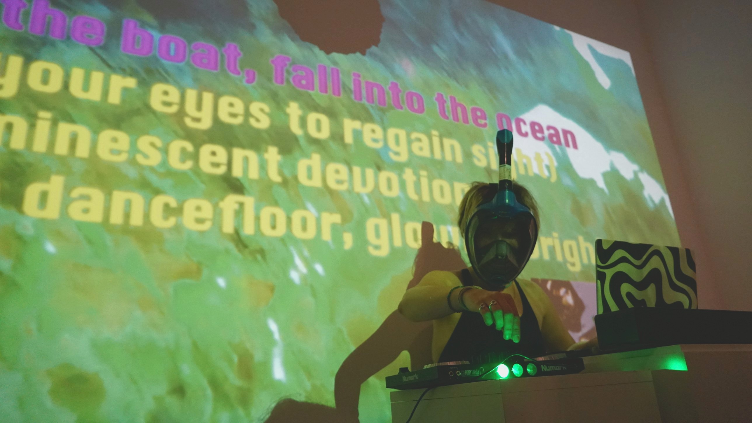 DJ Bubblz performing in a snorkel mask in front of the projected lyrics